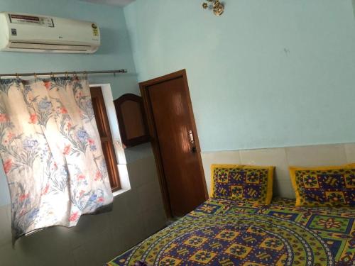 een slaapkamer met een bed, een raam en een ventilator bij Hotel Deep Mandir in Jaipur