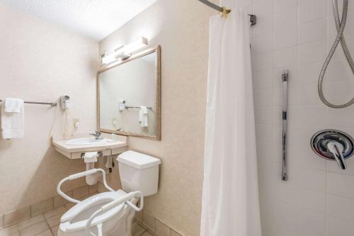 a bathroom with a toilet and a sink and a mirror at Quality Inn & Suites in Brainerd