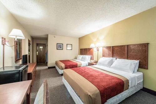a hotel room with two beds and a desk at Econo Lodge in Brainerd