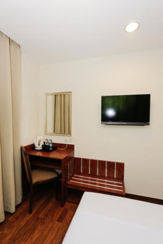 a room with a desk and a mirror on the wall at My Hotel @ KL Sentral in Kuala Lumpur