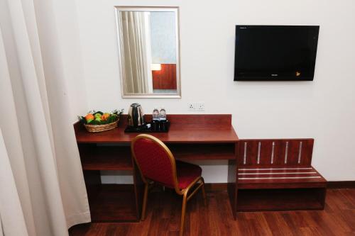 a desk with a chair and a television on a wall at My Hotel @ KL Sentral in Kuala Lumpur