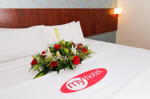 a bouquet of flowers on a bed in a hotel room at My Hotel @ KL Sentral in Kuala Lumpur