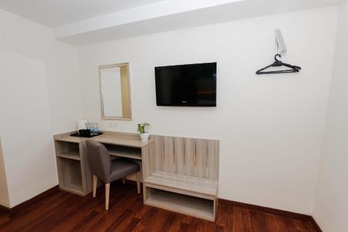 a desk with a mirror and a television on a wall at My Hotel @ KL Sentral in Kuala Lumpur