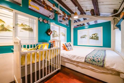 ein Kinderbett in einem Zimmer mit blauen Wänden in der Unterkunft Cat Sky Country Homestay in Xingjian