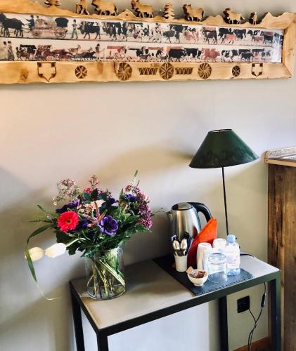 a vase of flowers on a table with a lamp at Coeur des Neiges in Saint-Gervais-les-Bains