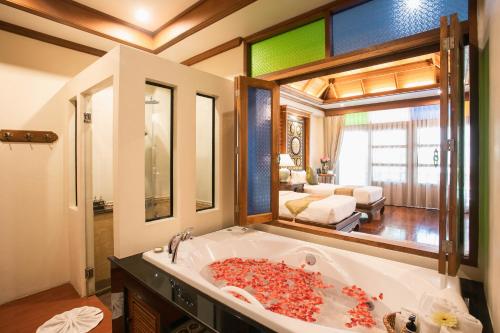 a bathroom with a large tub filled with red debris at Pingviman Hotel in Chiang Mai