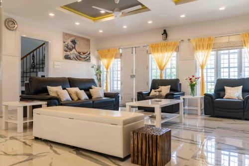 a large living room with couches and a table at StayVista at Aashirwaad Villa in Coonoor