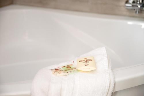 a towel on a bathroom sink with a book on it at VILLA CENTRUM APARTMÁNY s RAŇAJKAMI A SAUNOU in Martin