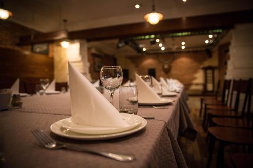a table with plates and wine glasses and napkins at Alpen Ville in Almaty