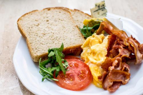 a plate of breakfast food with eggs bacon and toast at Hotel Floryan Old Town in Kraków
