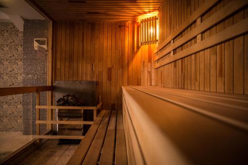 a sauna with wooden walls and a wooden floor at Alpen Ville in Almaty