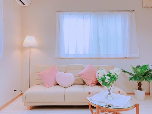 a living room with a couch with a heart pillow and a table at Awaji Seaside Resort Kuruma52 in Awaji
