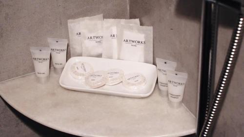 a table with a white tray and some bags on it at Artworks Hotel Ipoh in Ipoh