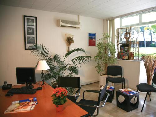 una oficina con escritorio y sillas en una habitación en Lagrange Vacances Les Trois Rivières en Mandelieu-la-Napoule