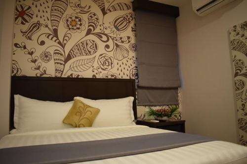 a bedroom with a bed with a flowery wallpaper at Hotel MM @ Sunway in Petaling Jaya