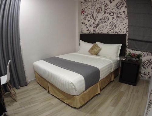 a bedroom with a large bed with white sheets at Hotel MM @ Sunway in Petaling Jaya
