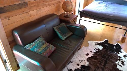 a leather couch with two pillows on it in a bedroom at Alice's Secret Travellers Inn in Alice Springs