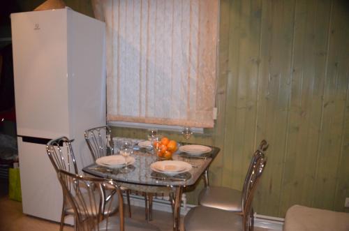 a dining room table with chairs and a refrigerator at Lubimiy Prichal in Zaborki