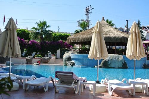 - une piscine avec des chaises et des parasols dans un complexe dans l'établissement Begonville Hotel, à Marmaris