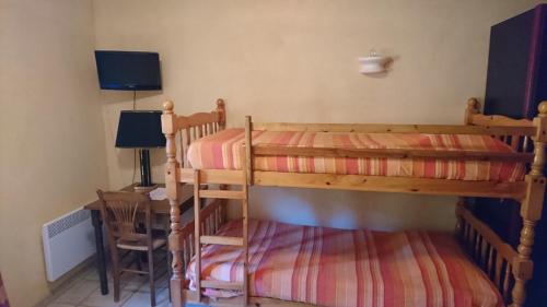 een slaapkamer met 2 stapelbedden en een tafel bij Hotel Les Cavalets in Bauduen