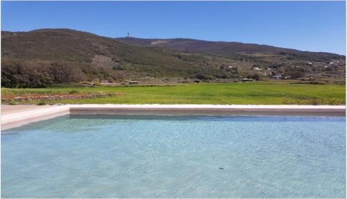 a pool of water with mountains in the background at 2 Gatti - Sogno in Pantelleria