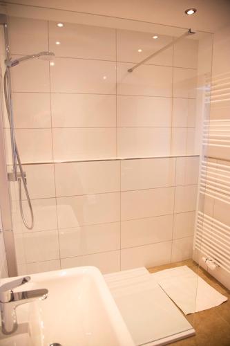 a white bathroom with a shower and a tub at Hotel Zum Goldenen Stern in Prüm