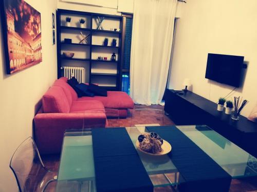 a living room with a red couch and a glass table at Residence Vigliani in Milan