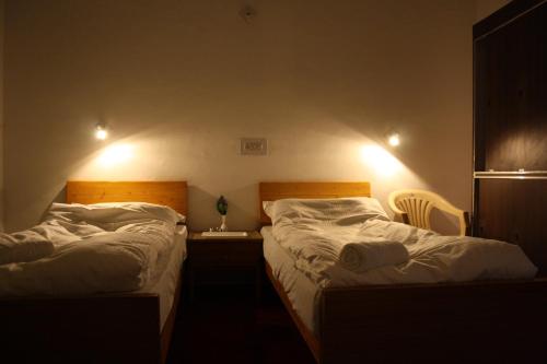 two beds sitting next to each other in a bedroom at Hotel Khan Manzil in Leh