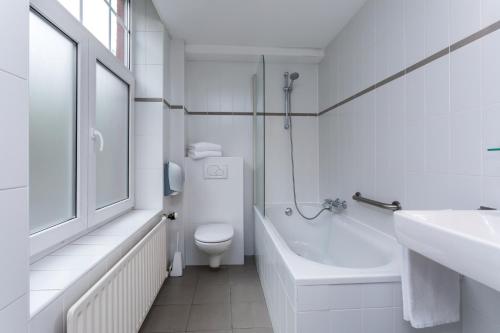 
a bathroom with a sink, toilet and bathtub at Berghotel Vue in Berg en Terblijt
