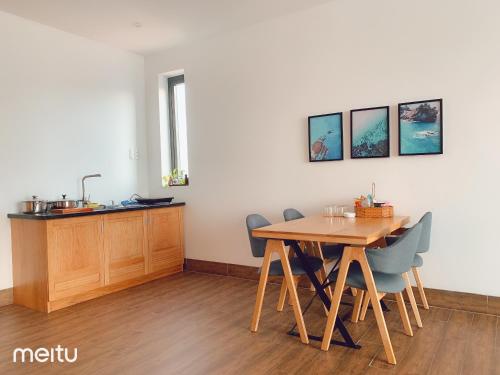 een eetkamer met een houten tafel en stoelen bij Nếp Apartment Hotel in Vung Tau