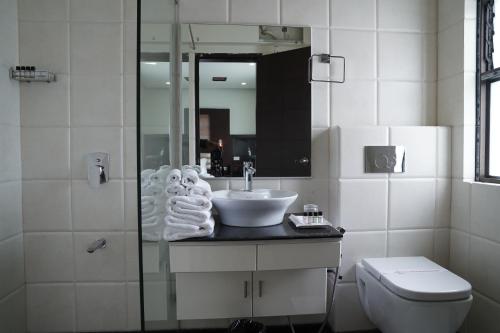 a bathroom with a sink and a toilet and a mirror at HOTEL ANNAPURNA in Vishnupur