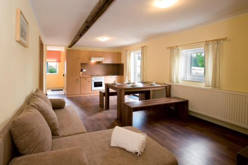 a living room with a couch and a table at Bergoase Panorama-Apartments in Kirnitzschtal