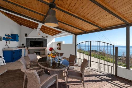 a dining room with a table and chairs on a balcony at Villa Lilly in Podgora
