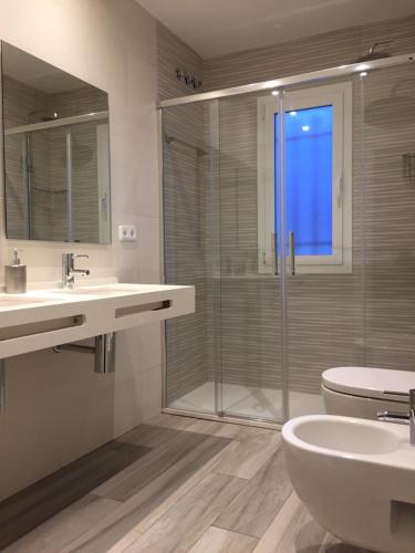 a bathroom with a shower and a sink and a toilet at Penthouse Asuncion Feria in Seville