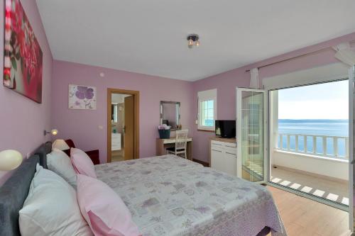 a bedroom with a bed and a view of the ocean at Villa Lilly in Podgora