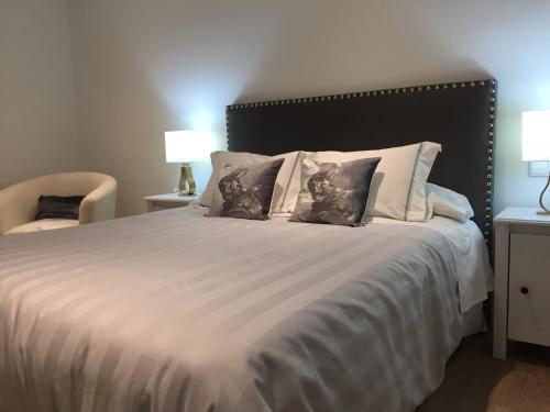 a bedroom with a large white bed with two pillows at Penthouse Asuncion Feria in Seville