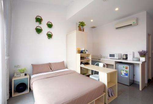 ein kleines Schlafzimmer mit einem Bett und einem Schreibtisch in der Unterkunft Babylon Serviced Apartment in Ho-Chi-Minh-Stadt