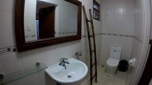 a bathroom with a sink and a mirror and a toilet at Luxor Resort and Restaurant in Gasan