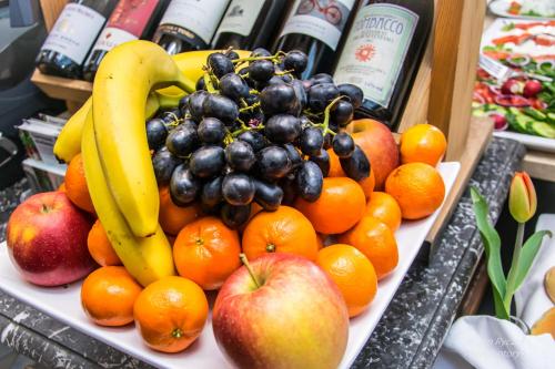 a plate of fruit with apples oranges and bananas at Hotel Floryan Old Town in Kraków