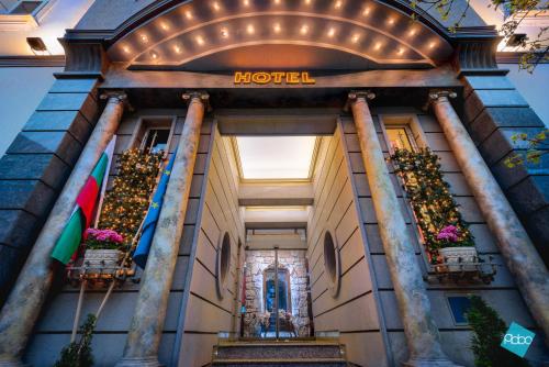 a hotel entrance with potted plants and a hotel sign at Art 'Otel in Sofia