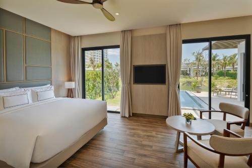 a bedroom with a large bed and a living room at Melia Ho Tram Beach Resort in Ho Tram