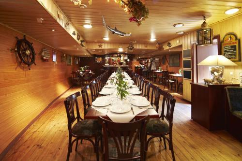 烏斯特羅的住宿－Hotelschiff Stinne，长长的用餐室配有长桌子和椅子
