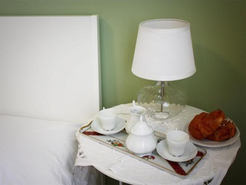 a table with a lamp and tea cups and croissants at Bed And Breakfast 22 Garibaldi Home in Riccione