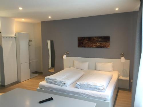 a bedroom with a white bed and a white table at Hotel-Fritz in Valwig