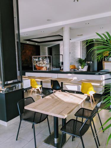 une salle à manger avec des tables et des chaises jaunes dans l'établissement Hotel Mira-Mar, à Valras-Plage