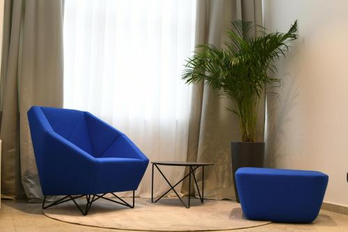 two blue chairs and a table and a plant at Aparthotel Milenij in Baška Voda