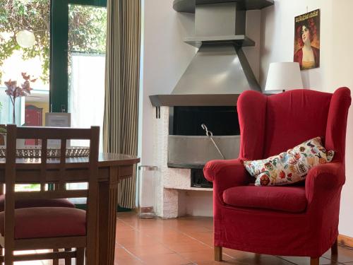 a living room with a red chair and a fireplace at Le Residenze dei Serravallo in Trieste