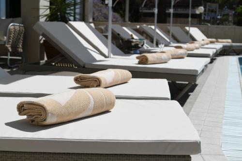 a row of lounge chairs with towels on them at Aparthotel Milenij in Baška Voda