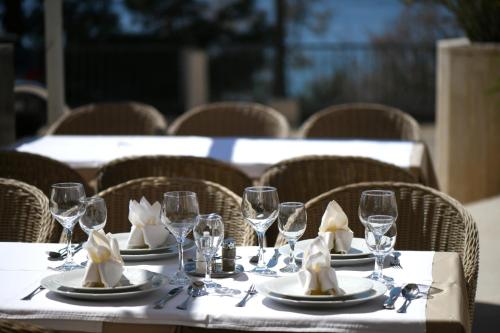 a table with plates and wine glasses and napkins at Aparthotel Milenij in Baška Voda