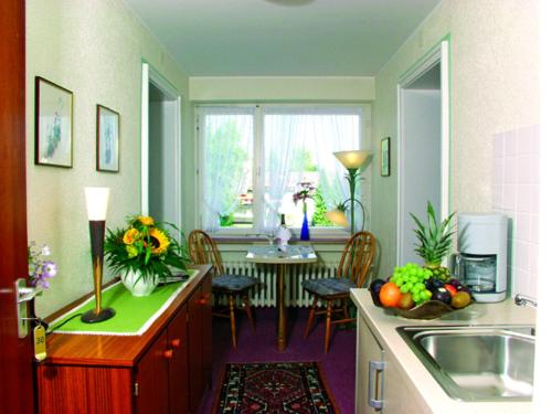 a kitchen with a sink and a table with chairs at Kurhotel Weber in Bad Wörishofen